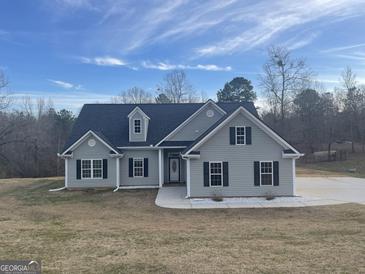 Charming single-story home with gray siding, black shutters, and a well-maintained front yard at 1029 Hines Rd, Moreland, GA 30259