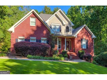 Charming two-story red brick home with a beautifully landscaped front yard and mature plantings at 417 Harper Rd, Mcdonough, GA 30252