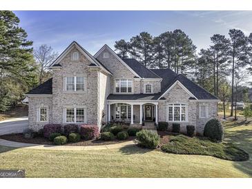 Stately brick home featuring manicured landscaping, a columned front porch, and a symmetrical facade at 415 Oxmoor Lake Dr, Mcdonough, GA 30252