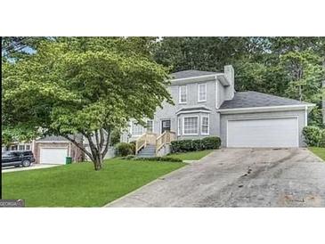 Charming two-story home with a well-maintained front yard and attached two-car garage at 6380 Phillips Pl, Lithonia, GA 30058