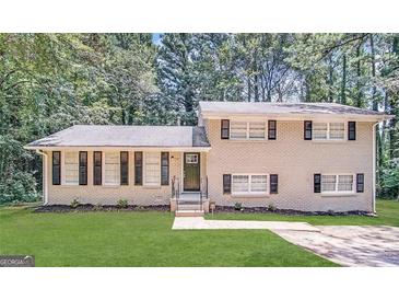 Charming two-story home with a brick facade, green lawn, and well-maintained landscaping at 1965 Rollingwood Se Dr, Atlanta, GA 30316