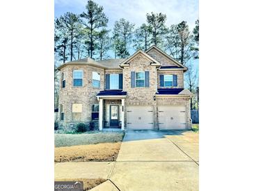 Beautiful two-story brick home with a two-car garage and well-maintained lawn, surrounded by mature trees at 9444 Lantana Trail, Jonesboro, GA 30238