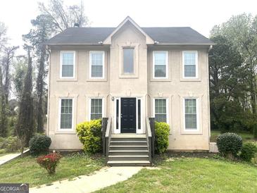 Two-story home showcasing a black front door, and a well-manicured lawn and shrubbery at 3497 Thornewoode Pointe, Decatur, GA 30034