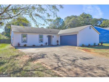 Charming single-story home features a spacious driveway and attached two-car garage at 5495 Reynolds Rd, Morrow, GA 30260