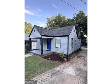 Charming single Gathering home with a blue front door and well manicured front lawn at 1066 Ashby Sw Grv, Atlanta, GA 30314