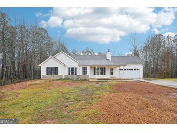 Charming single-story home featuring white siding, black shutters, attached garage, and spacious front yard at 521 Cody Ln, Mcdonough, GA 30252