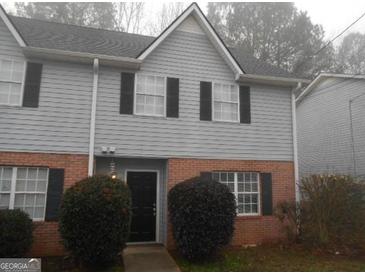 Charming two-story townhome featuring gray siding, brick accents, and well-maintained front shrubs at 4341 Logan Way, Acworth, GA 30101