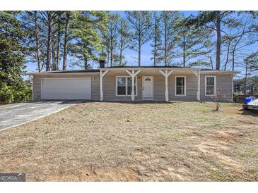 Charming ranch-style home featuring a covered porch, attached garage, and mature trees at 4097 Cripple Creek Nw Dr, Kennesaw, GA 30144