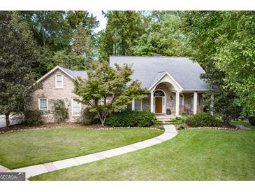 Charming brick home with a manicured lawn and lush landscaping creates a welcoming curb appeal at 2275 Honeysuckle Se Ln, Smyrna, GA 30080