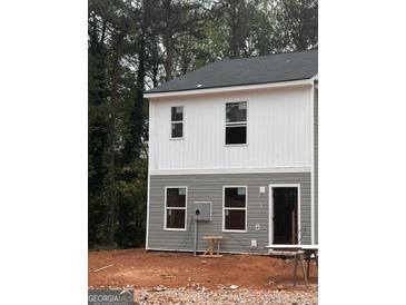 Two-story home features gray and white siding, dark roof, and surrounded by lush trees at 7266 Crestside Dr # 65, Austell, GA 30168