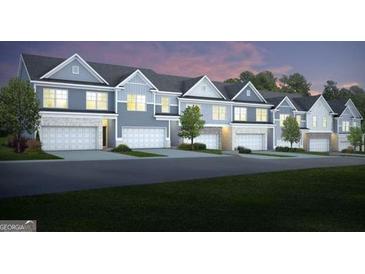 Beautiful townhome exteriors, complete with garages and landscaped lawns, at dusk at 1330 Magnolia Bend Way # 306, Jonesboro, GA 30238