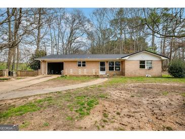 Charming single-story brick home featuring an attached garage and well-maintained front yard at 2864 S 100 Hwy, Bowdon, GA 30108