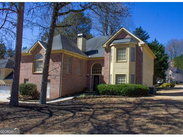 Charming two-story brick home featuring a well-manicured lawn and inviting front entrance at 613 Mountain Oaks Pkwy, Stone Mountain, GA 30087