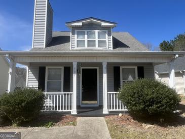 Charming home featuring a cozy front porch with white columns and well-manicured landscaping at 607 Tramore Ct, Stockbridge, GA 30281