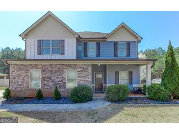 Charming two-story home featuring stone accents, covered porch, and well-maintained landscaping at 4205 Lindsey Way, Conyers, GA 30013