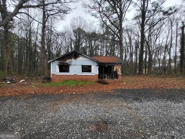 Exterior shot of a damaged single story house with a brick foundation at 2954 Orchard Ln, Atlanta, GA 30354