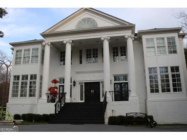 Majestic white brick home with grand columns and elegant architectural details for timeless appeal at 337 Lakeshore Dr, Berkeley Lake, GA 30096