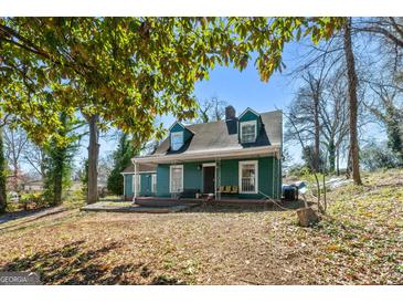 Charming two-story home with a covered front porch and dormer windows nestled under mature trees at 1444 Norman Berry Dr, East Point, GA 30344