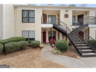 Charming condo building featuring tidy landscaping and eye-catching red doors at 555 Windchase Ln, Stone Mountain, GA 30083