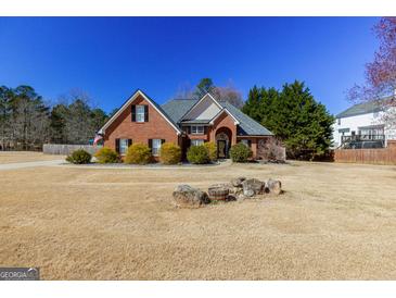 Charming brick home with a symmetrical design and well-manicured landscaping at 140 Surrey Park Dr, Fayetteville, GA 30215