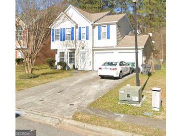 Charming two-story home featuring blue shutters, a well-maintained lawn, and an attached two-car garage at 775 Windemere Oak Nw Way, Lilburn, GA 30047