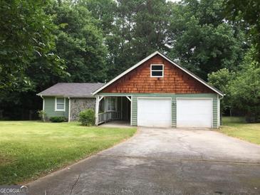 Charming home with a two-car garage, wood, and stone elements at 9091 Woodgreen Way, Jonesboro, GA 30238