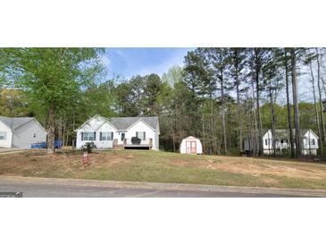 Charming single-Gathering home with a well-maintained lawn and a storage shed in a wooded neighborhood at 220 Joe Dr, Temple, GA 30179