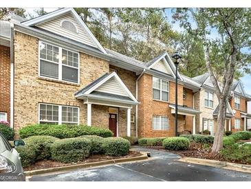 Brick townhome exterior showcasing manicured landscaping and assigned parking at 3802 Austin Park Ln, Decatur, GA 30032