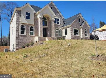 Stunning two-story home with classic brick facade and arched entryway detailing at 4604 Mossey Dr, Stonecrest, GA 30038