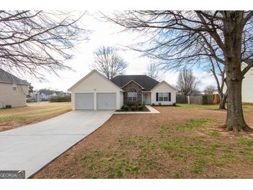 Charming ranch home with a two-car garage, stone accents, and well-maintained lawn at 1632 Zacharys Way, Mcdonough, GA 30253