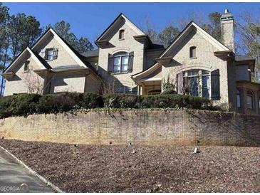 Stately brick home featuring multi-level roof lines and manicured landscaping at 852 Oakton Pond Nw Ct, Marietta, GA 30064
