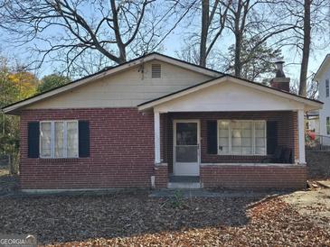 Exterior view of brick single-story home with mature trees and landscaping at 953 South Ave, Forest Park, GA 30297