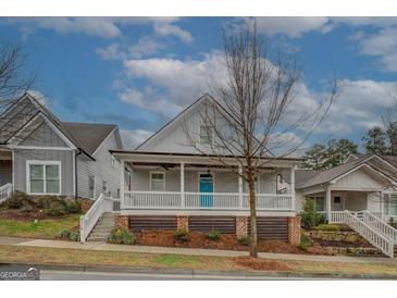 Charming two-story home featuring a spacious front porch with blue door and well-maintained landscaping at 5118 N Pratt St, Covington, GA 30014