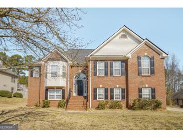 Charming two-story brick home featuring black shutters and a well-manicured front yard at 1421 Saint Charles Ct, Conyers, GA 30094