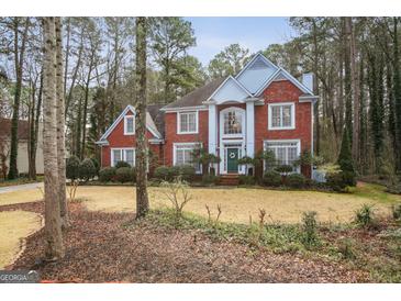 Charming red brick two-story home with mature landscaping, offering classic elegance and curb appeal at 9163 Retreat Pass, Jonesboro, GA 30236