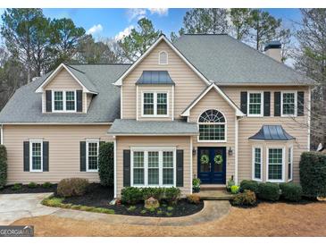 Charming two-story home featuring a well-manicured lawn, a blue front door, and classic architectural details at 220 Terrane Rdg, Peachtree City, GA 30269