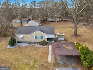 An eye-level view of a charming single-story home, complete with a quaint carport and a sprawling yard at 6393 Walker Rd, Riverdale, GA 30296