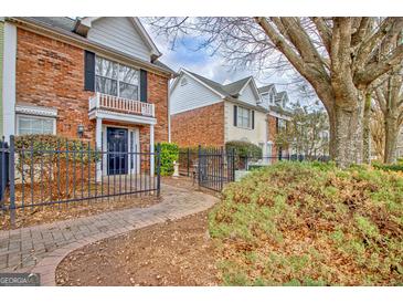 Charming brick townhome featuring a manicured front yard and walkway, inviting curb appeal at 498 N Jeff Davis Dr, Fayetteville, GA 30214