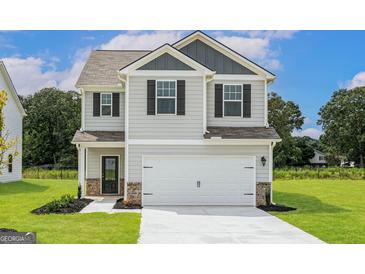 Charming two-story home features a two-car garage and inviting front lawn at 293 Limestone Circle, Conyers, GA 30013