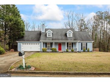 Charming single-Gathering home with a well-manicured lawn, a two-car garage, and a welcoming red front door at 10 Allen Oaks Way, Covington, GA 30016