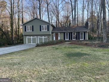 Charming two-story home features a two-car garage, complemented by dark shutters and well-kept lawn at 3370 Creek Hollow Dr, Marietta, GA 30062