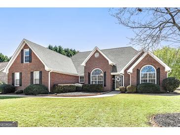 Beautiful brick home with a well-manicured lawn and mature landscaping at 1000 Maria Dr, Mcdonough, GA 30253