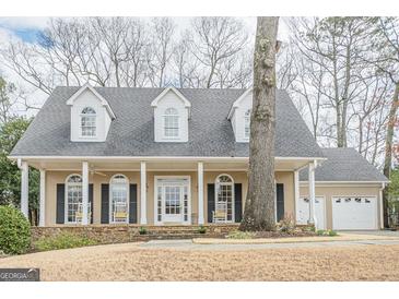 Charming home featuring a welcoming front porch with a stone base and a beautiful facade at 6360 Brookline Ct, Cumming, GA 30040