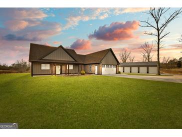 Beautiful exterior of a modern home with a large yard and matching three-bay garage at 10 Last St, Moreland, GA 30259