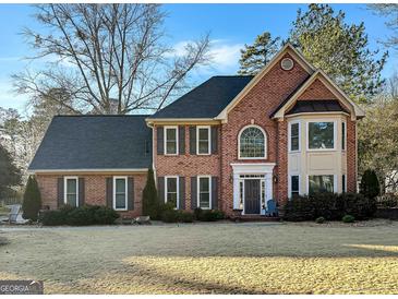Charming two-story brick home featuring a well-manicured lawn and a classic architectural design at 407 Holly Grove Church Rd, Peachtree City, GA 30269