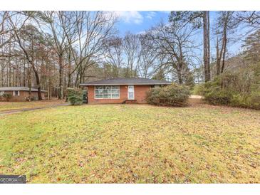 Charming brick home with a well-maintained front yard and mature trees at 1115 Highway 54 East, Fayetteville, GA 30214
