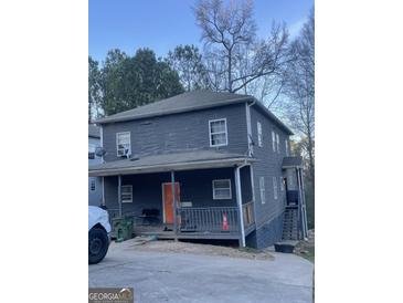 Two-story home featuring a covered front porch and ample parking at 1973 Jones Nw Ave, Atlanta, GA 30318
