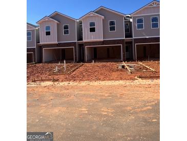 New construction townhomes feature attached garages and modern design elements at 11565 Kimberly Way # 24, Hampton, GA 30228