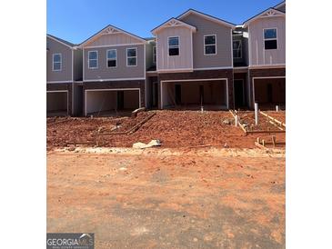 New townhome construction featuring brick accents, modern design, and a visible garage at 11563 Kimberly Way # 23, Hampton, GA 30228