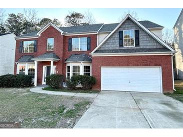 Charming two-story brick home with a well-maintained lawn and a two-car garage, offering great curb appeal at 6159 Sable Fox Dr, Riverdale, GA 30296